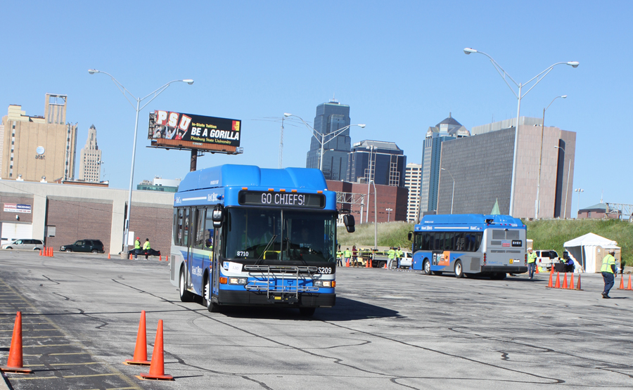 Bus operators compete with the Kansas City skyline in the background.